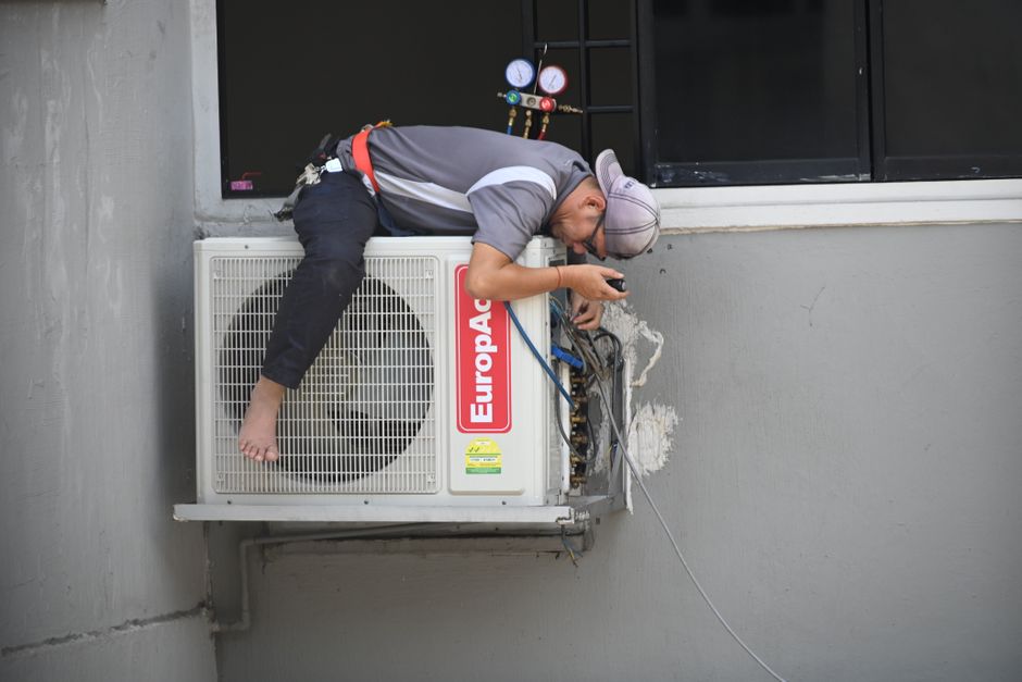 Friendly HVAC technician inspecting a home system